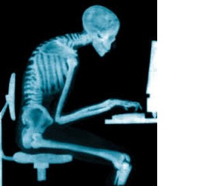 An x-ray of a person sitting down hunched over a computer