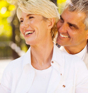 An older man and woman smiling together