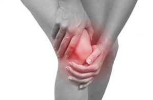 A person gripping their painful knee