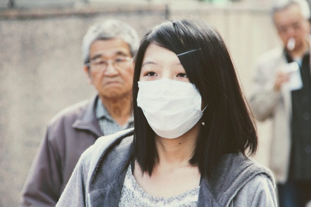 A woman wearing a respiratory mask over her nose and mouth