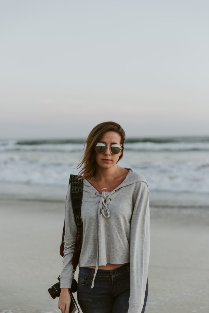 A woman wearing a loose fitting grey sweatshirt