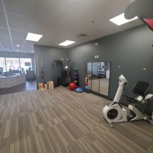 The inside of the Progressive Spine & Rehab Center office featuring an exercise bike and a mirror on the wall.
